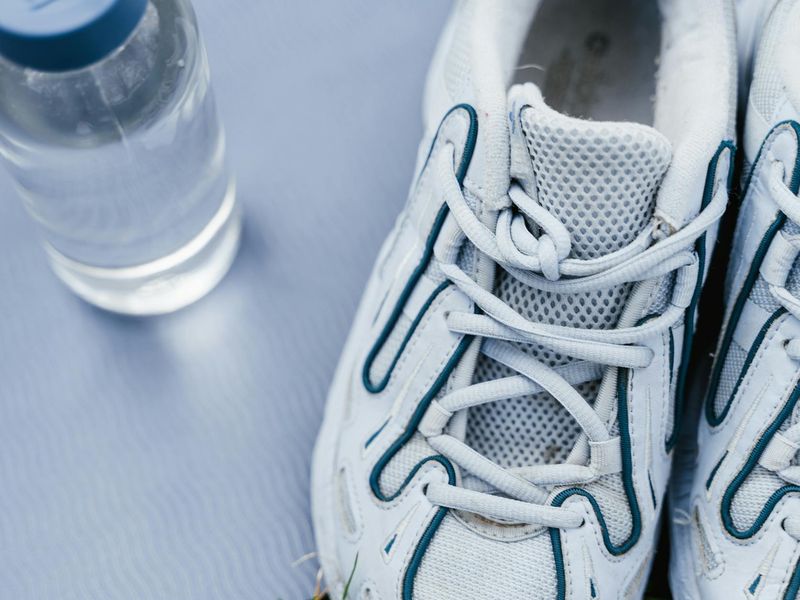 Details of sports equipment and sneakers on a clean floor.